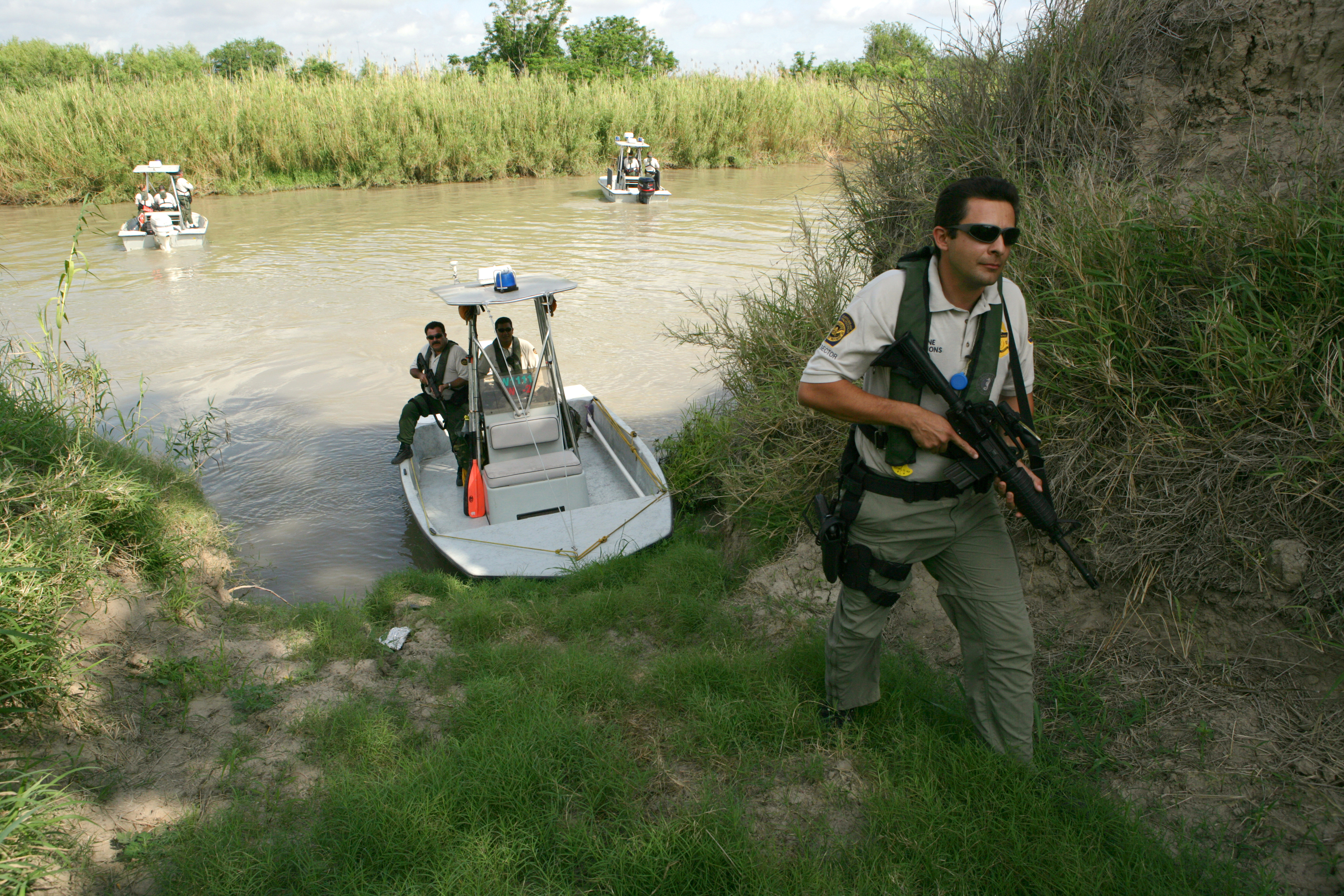 A CBP Border Patrol Agent investigates a potential landing area for illegal immigrants along the Rio Grande River in Texas