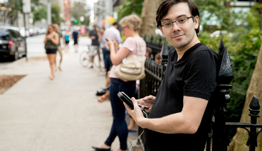 Former Turing Pharmaceuticals CEO Martin Shkreli, who said he was reporting using a video service called "periscope" on his smartphone, stands with reporters after Democratic presidential candidate Hillary Clinton leaves an apartment building Sunday, Sept. 11, 2016, in New York. Clinton's campaign said the Democratic presidential nominee left the 9/11 anniversary ceremony in New York early after feeling "overheated." (AP Photo/Andrew Harnik)